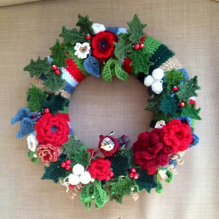 A Christmas wreath made of crocheted holly and flowers