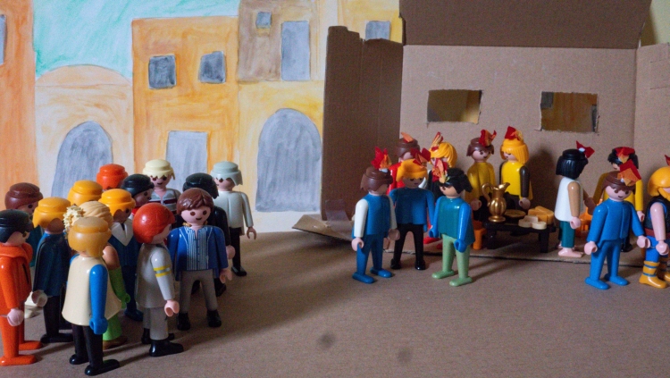 A Playmobil scene depicting the disciples with tongues of fire on their heads and a crowd gathering at Pentecost