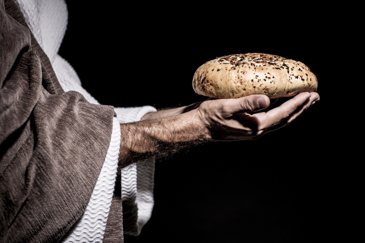 A man holding out a loaf of bread