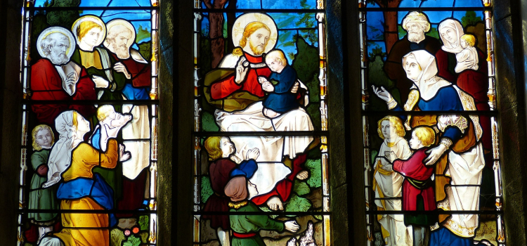 A stained glass window depicting Jesus with children