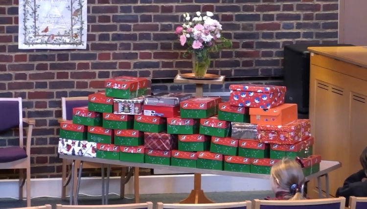 A table at the front of the chapel filled with shoeboxes for Operation Christmas Child