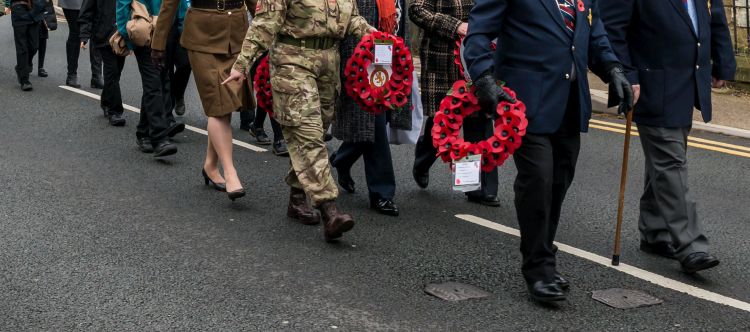 People marching with poppy wreaths in a Remembrance Sunday parade