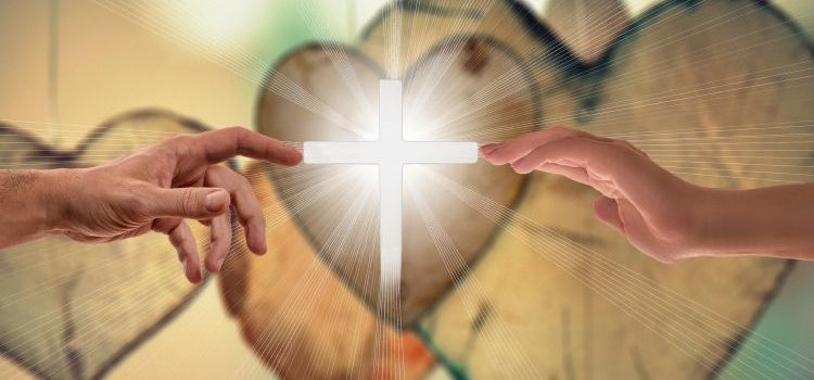 Hands reaching out to touch a cross in the middle of the picture with hearts in the background