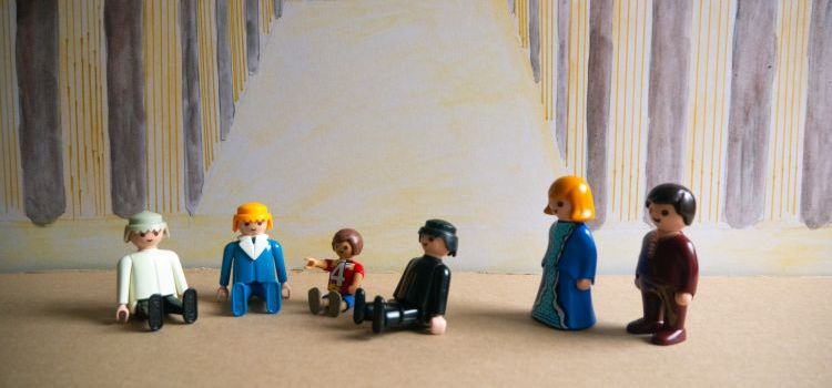 A Playmobil scene depicting the boy Jesus sitting and talking with the teachers at the temple with Mary and Joseph looking on
