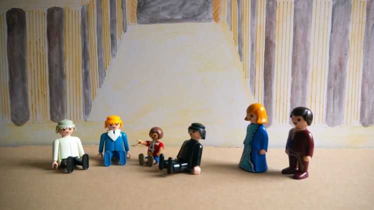 A Playmobil scene depicting the boy Jesus sitting and talking with the teachers at the temple with Mary and Joseph looking on