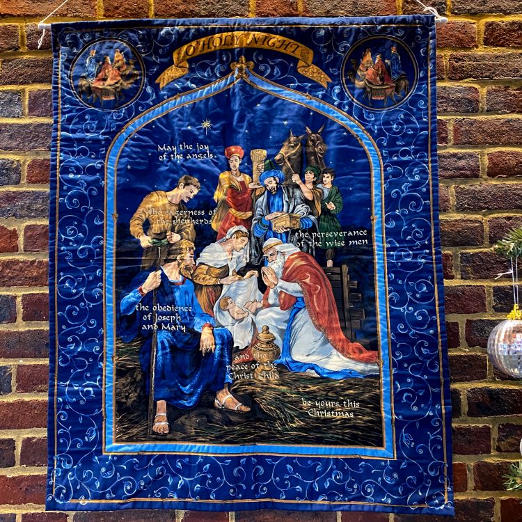 A wall hanging showing the wise men and shepherds visiting baby Jesus