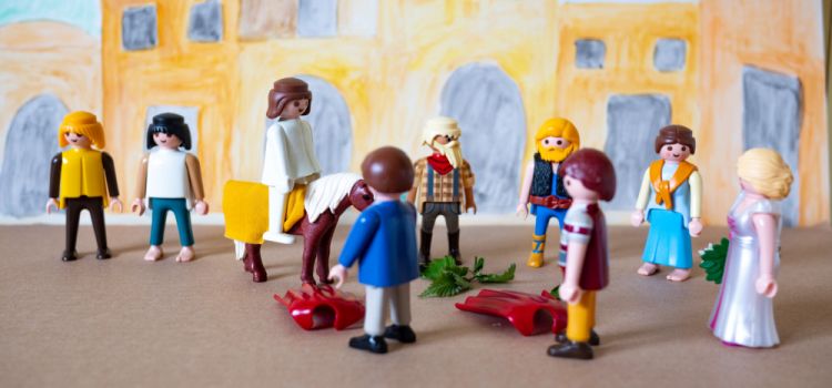 A Playmobil scene depicting Jesus's triumphal entry into Jerusalem riding on a colt with people spreading their cloaks before him