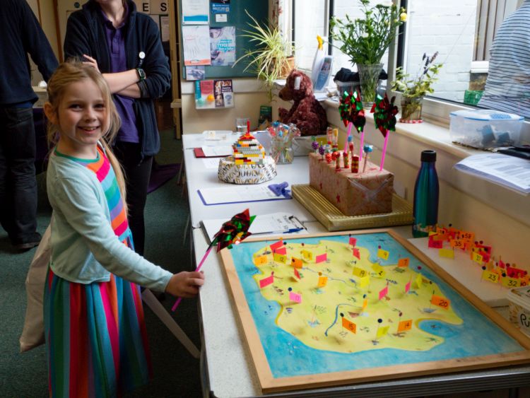 A girl in front of a game to place the flag on the treasure map