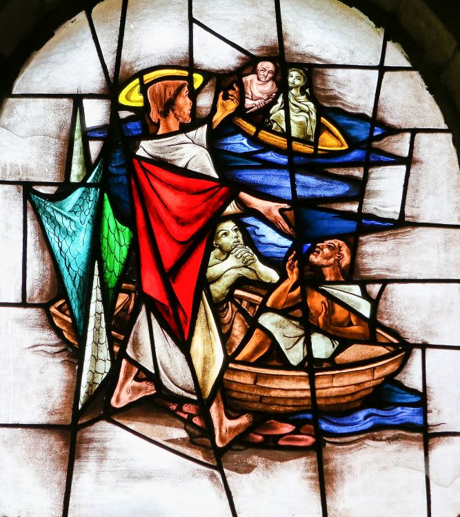 A stained glass window depicting Jesus calling four fishermen.