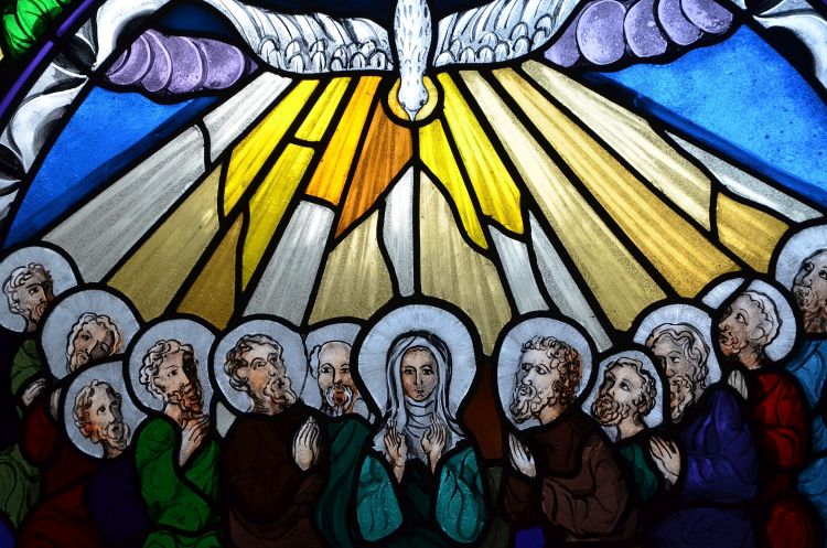 An illustration of the disciples with tongues of fire above them at Pentecost and a dove looking down