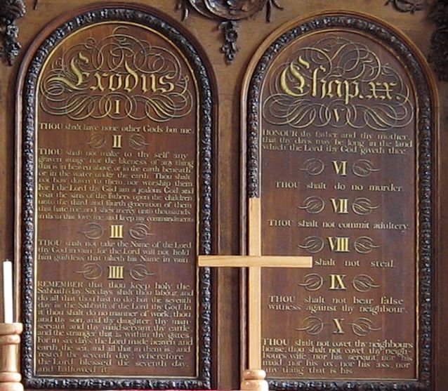 The ten commandments displayed on wooden panels at the back of a church.