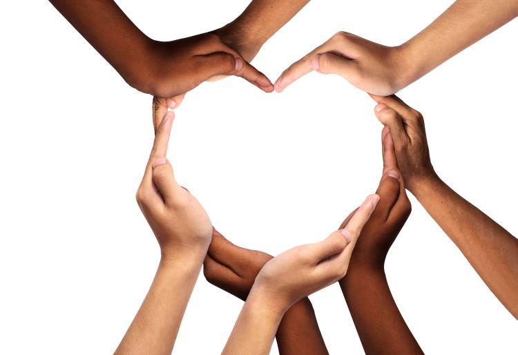 Hands from people of different ethnicities coming together to make a heart shape