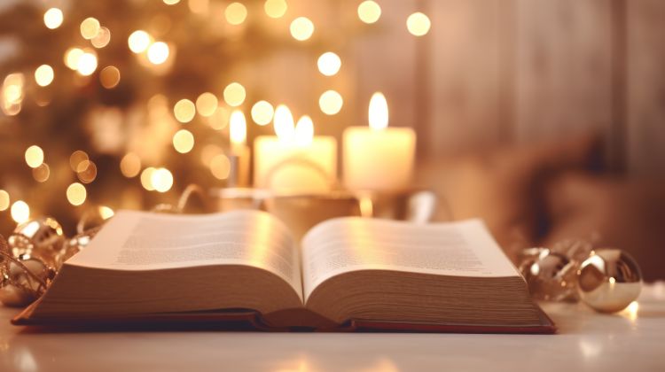An open Bible with candles and twinkly lights in the background