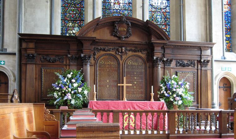 A church with a wooden board behind the altar showing the ten commandments