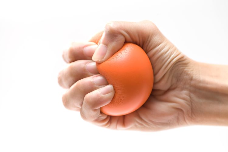 A hand squeezing a stress ball